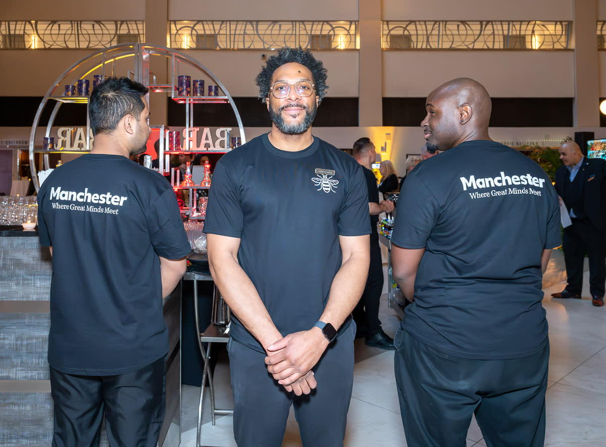 Bar staff wear Manchester branded uniforms for a cocktail reception