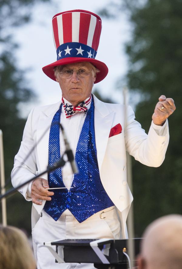A musical conductor dressed as Uncle Sam leads a symphony during a 4th of July concert in Fort Collins, CO.
