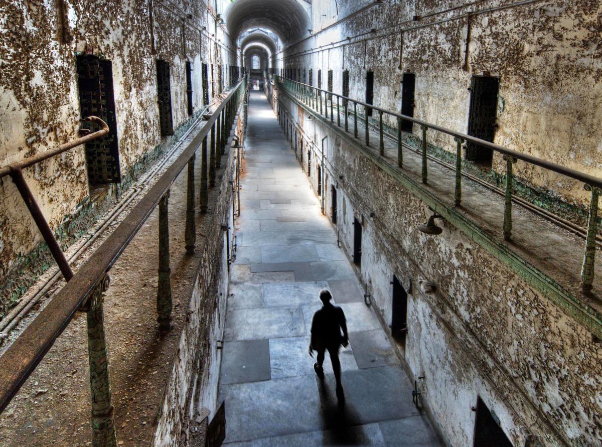 Person walking down a long eerie jail hallway