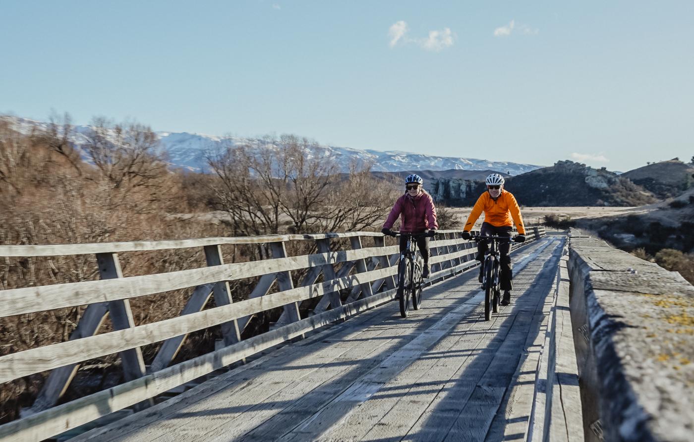 People biking over a bridge