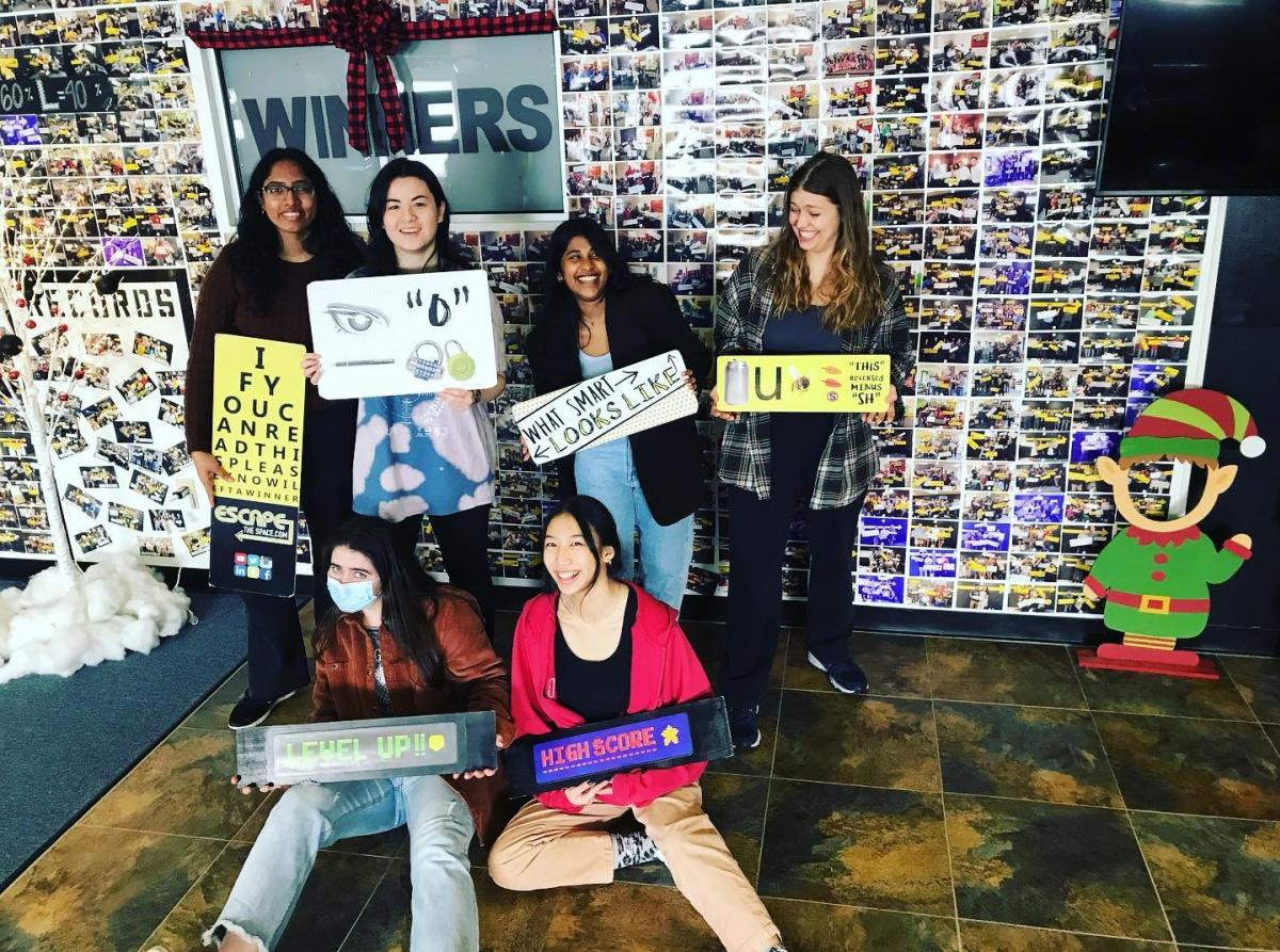 A group of six young women pose after completing an escape room at Escape the Space.