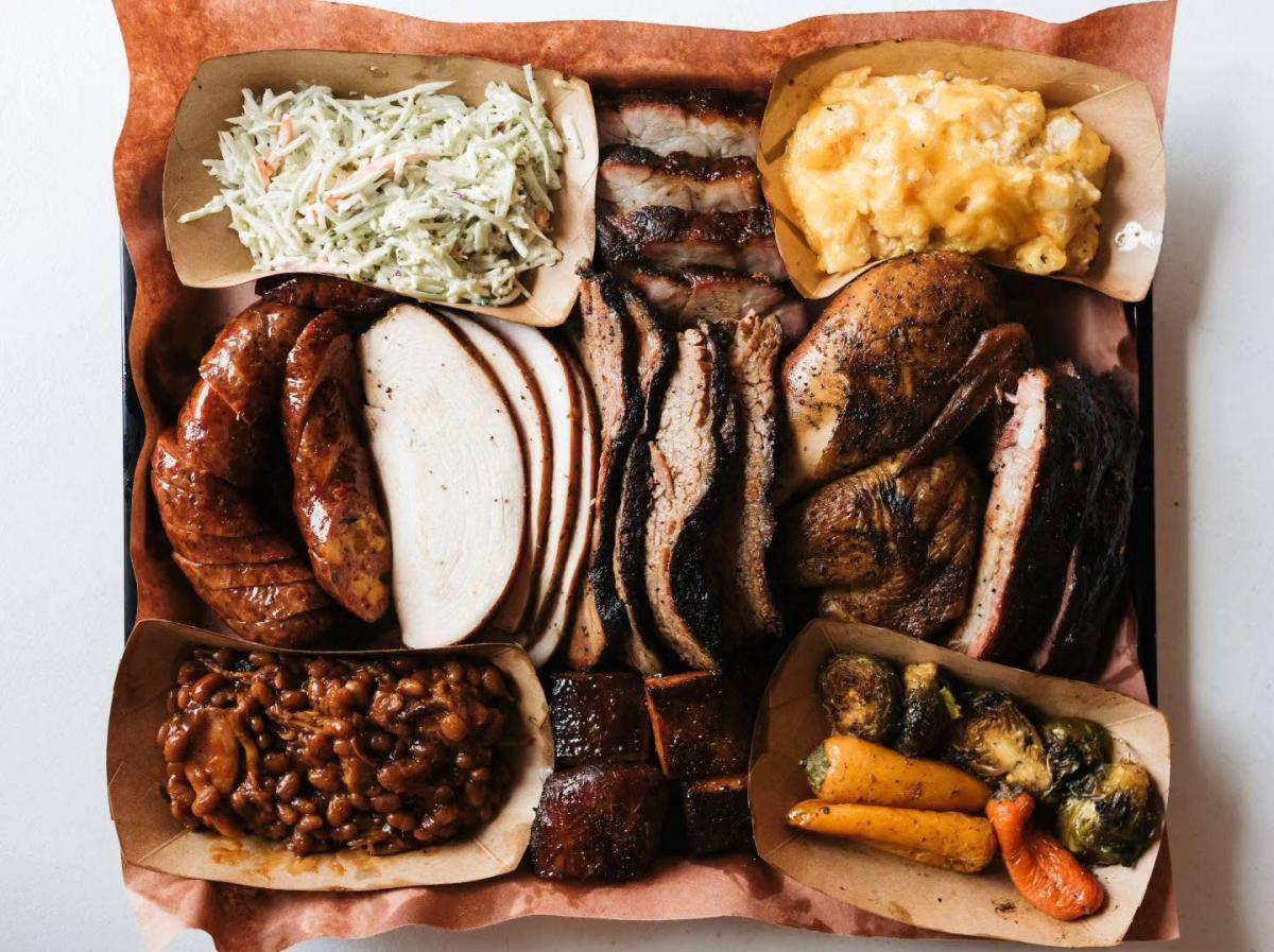 Delicious barbecue plate featuring different meats, slaw, macaroni and cheese, baked beans, and other veggies from Russell's BBQ in Sheffield.