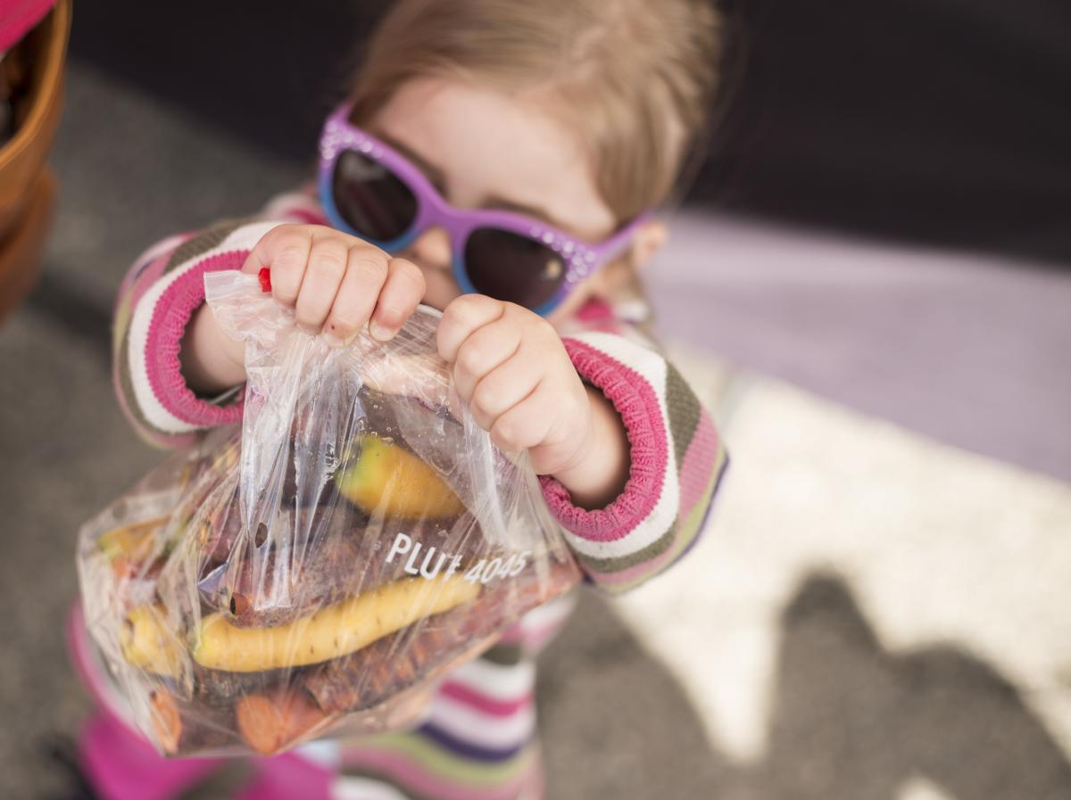 Little girl with bag of carrots