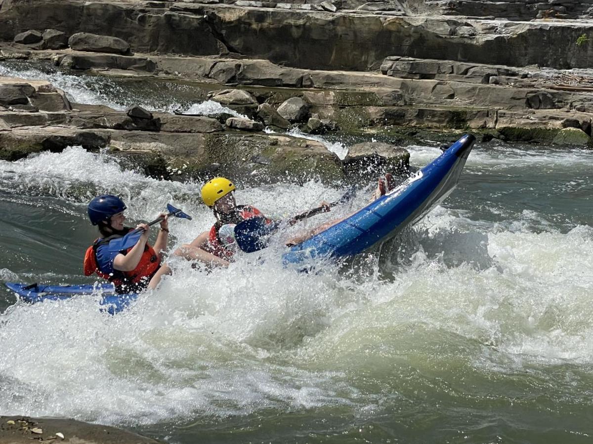 Two people in a raft in white water at WOKA Kayak Park.
