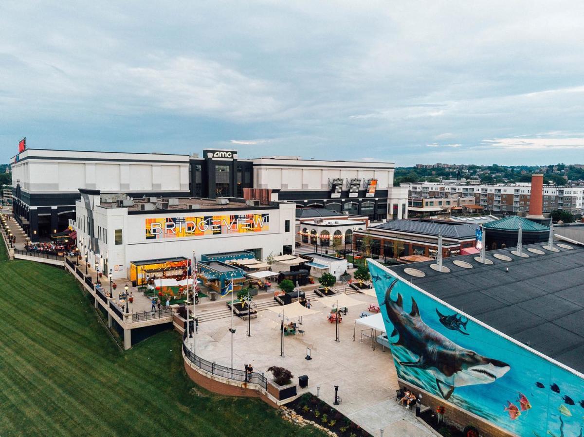 Image is an arial shot of Newport on the Levee featuring the Newport Aquarium, Bridgeview Box Park and AMC.