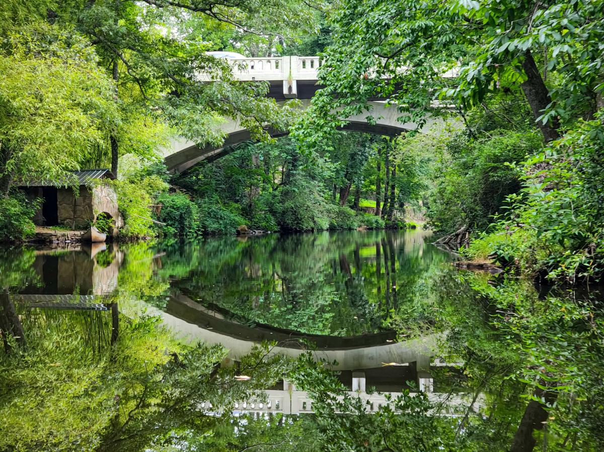 Beautiful trees and bridge reflecting on the creek at DeSoto State Park.