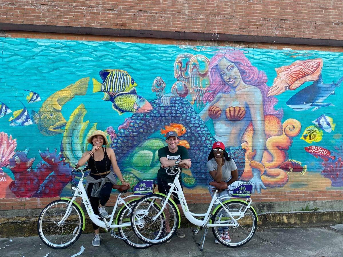 People In Beaumont TX On Their Beaucycles in front of a mural