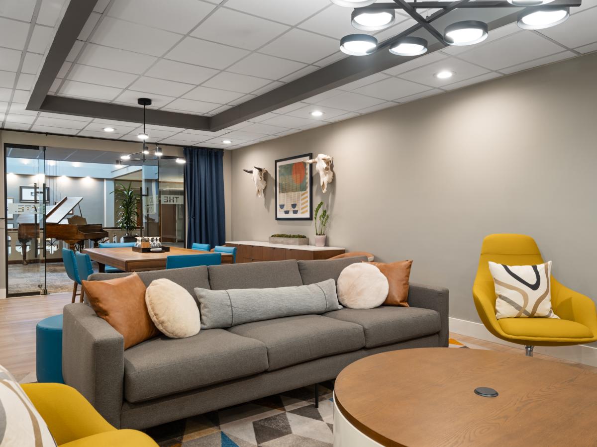 a small meeting room featuring a small board room table, couch, chairs and coffee table