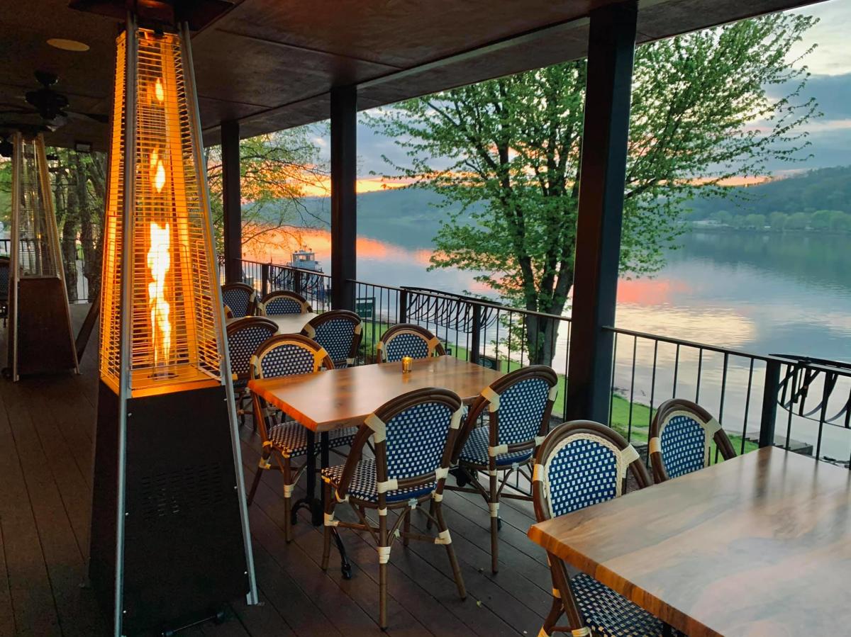 View of the top floor outdoor patio with a view of the Ohio River and a fire going.