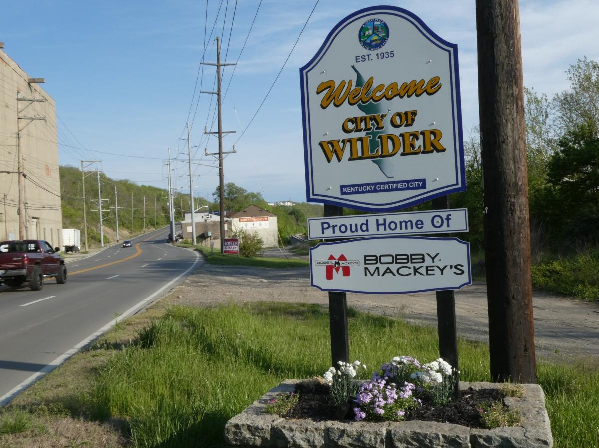 Image is of the "Welcome, City of Wilder" sign with another sign that says "Proud Home of Bobby Mackey's".