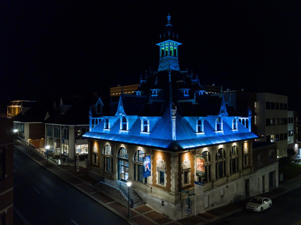 a historic, spired building with a blue under-lit rooftop