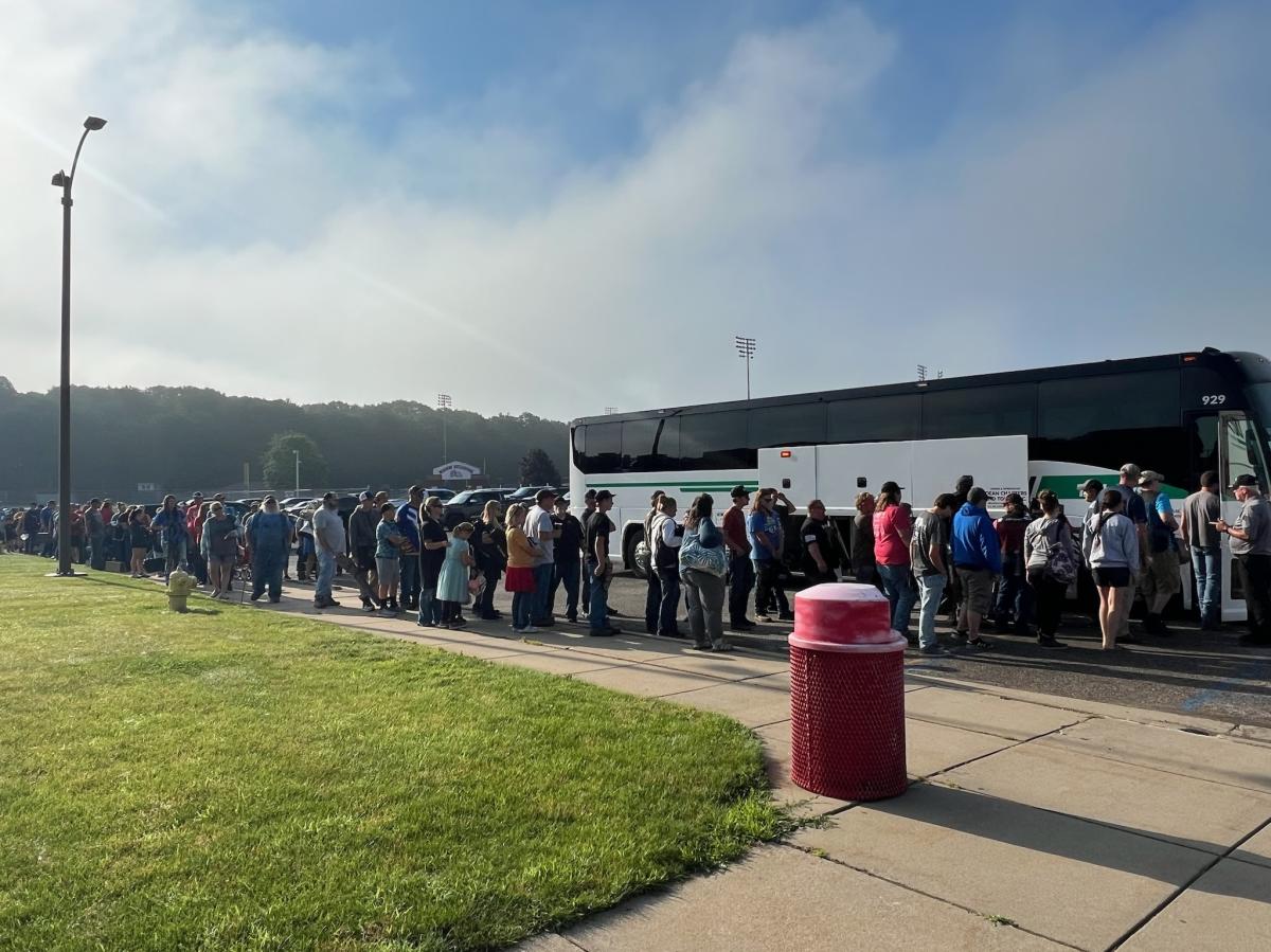 A long line of people waiting to get on a bus during the USA Clay Target Nationals in Mason.