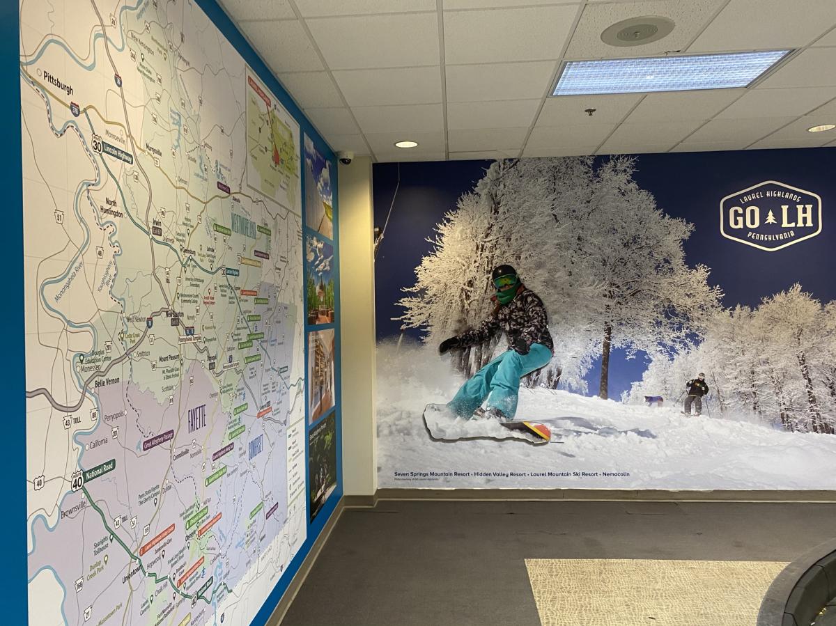 Regional map and three-dimensional skier welcome passengers at Arnold Palmer Regional Airport