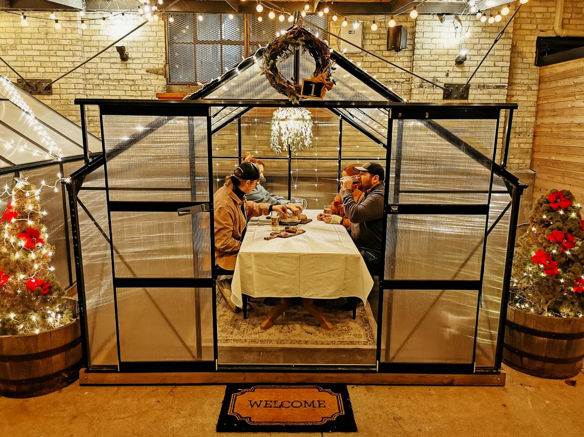 friends enjoying a drink in greenhouse