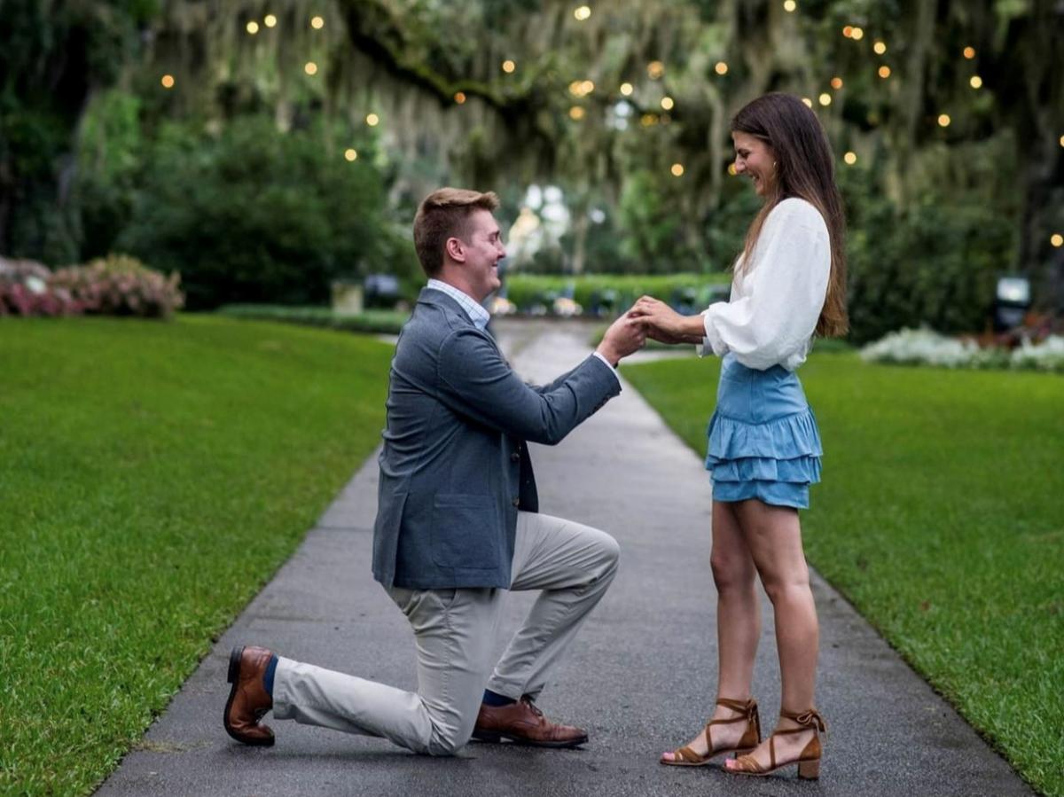 A man on his knee proposing to a woman at Brookgreen Gardens with Lights