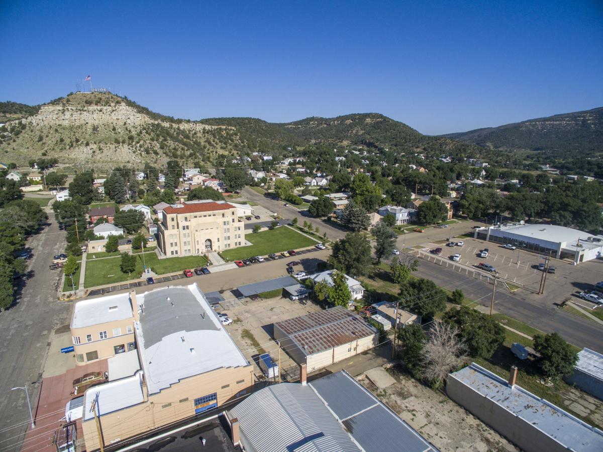 Aerial view of a small town surrounded by cliffs covered in green shrubs