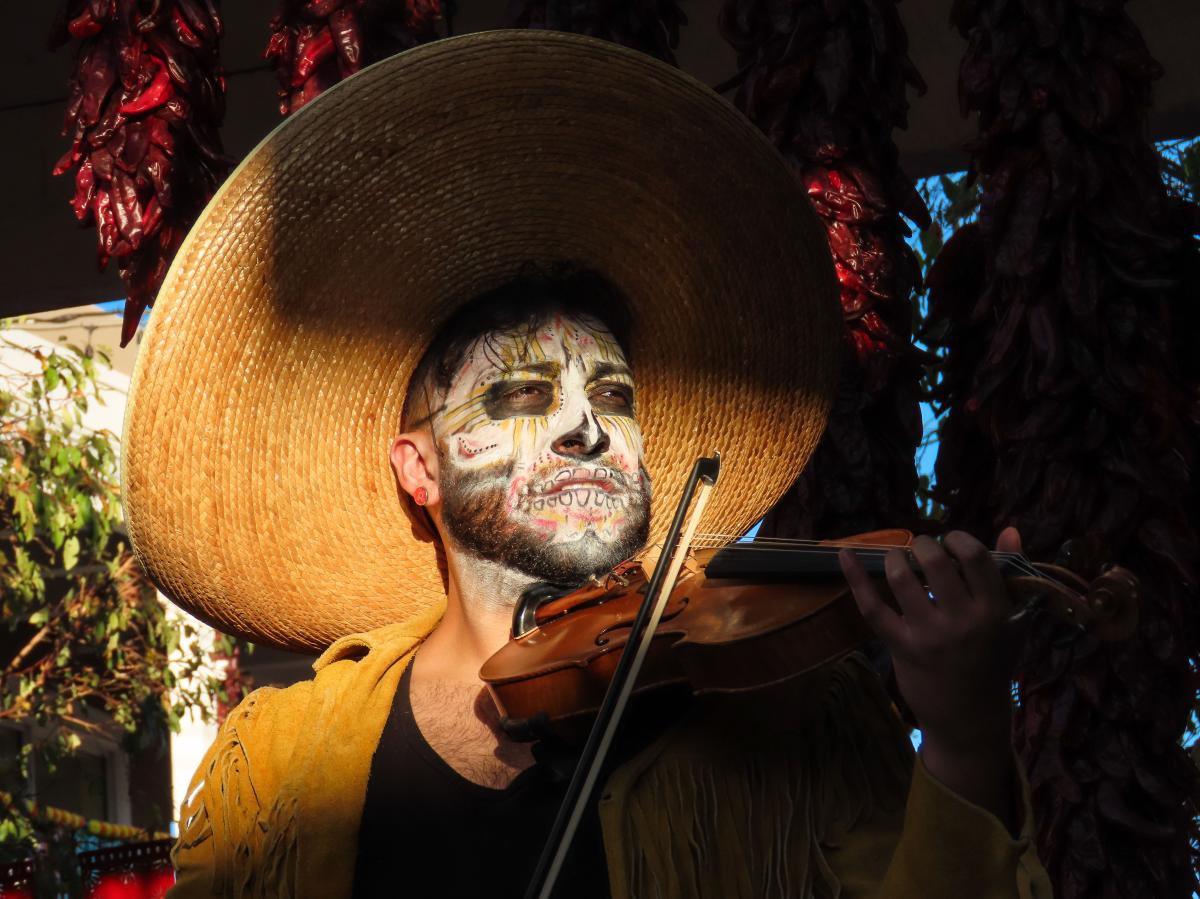 A mariachi musician plays violin in Old Town Albuquerque at sunset.