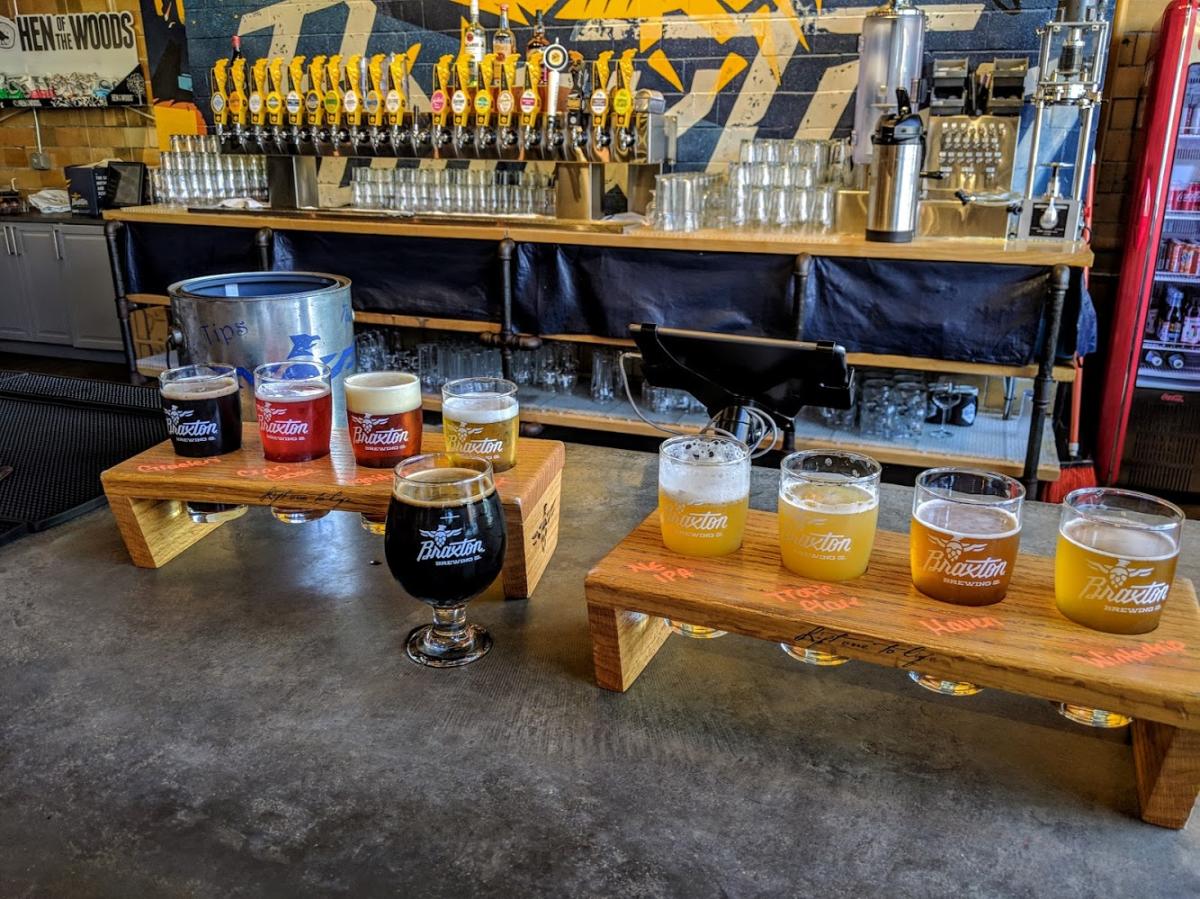 two beer flights on the bar at Braxton Brewery with the taps in the background