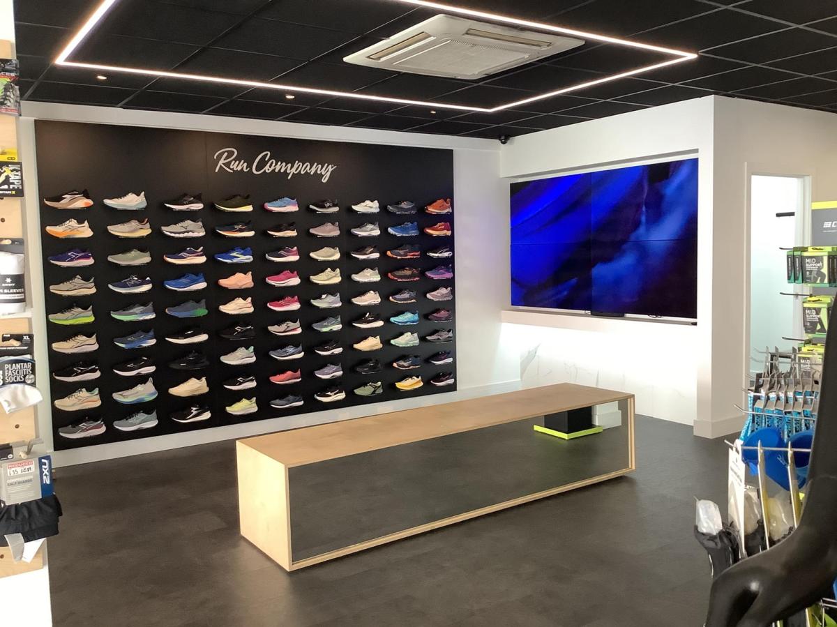 Wall display of new running shoes inside Run Company