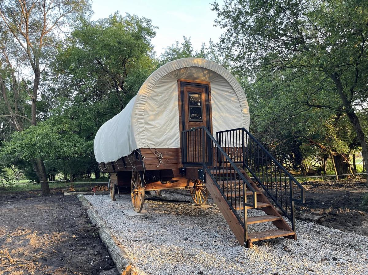 A covered wagon sits available to rent at Diamond Springs Ranch