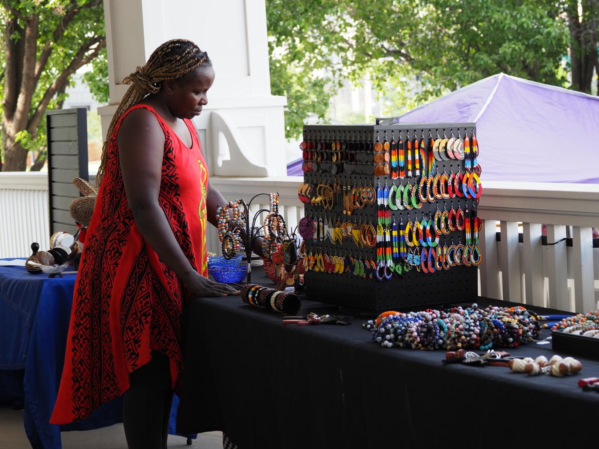 A woman shops for jewelry at an outdoor market