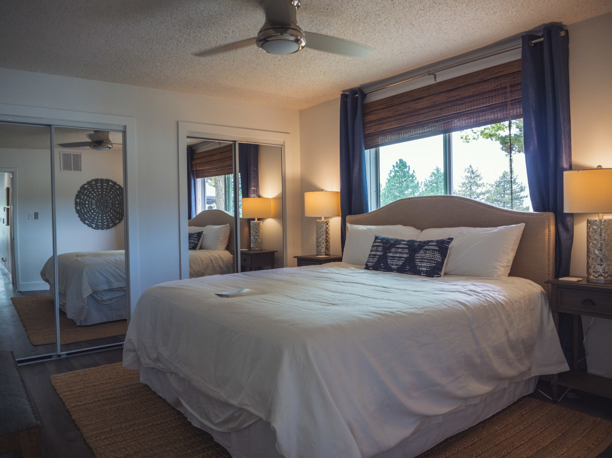 A queen-sized bed sits in a bedroom on the property of BrightWater Bay
