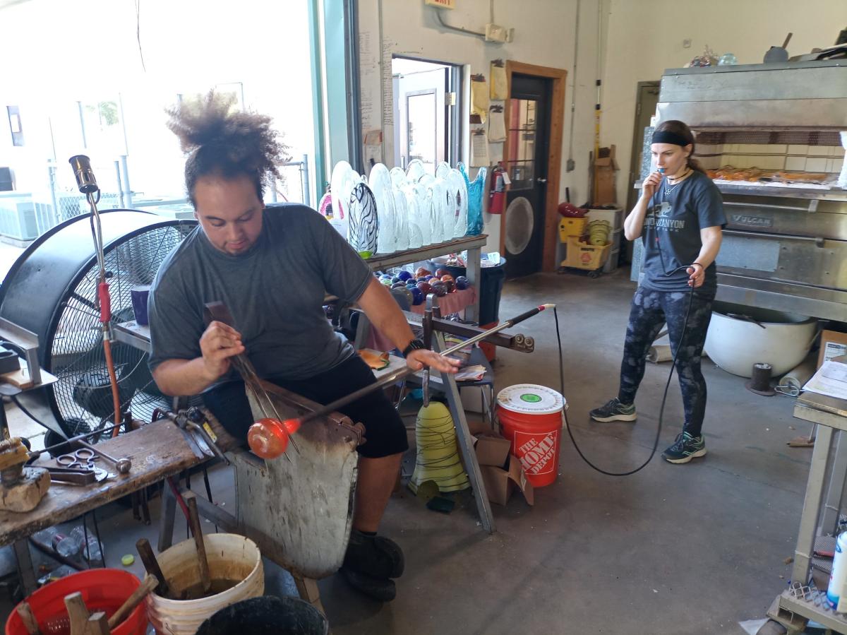 A glass blower works on a piece of glass artwork at Karg Art Glass.