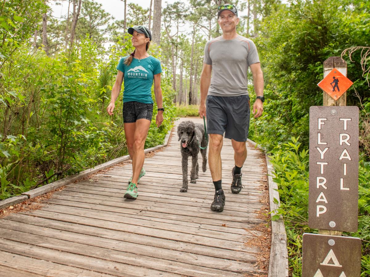 Couple walking with dog at Carolina Beach State Park  on Flytrap Trail