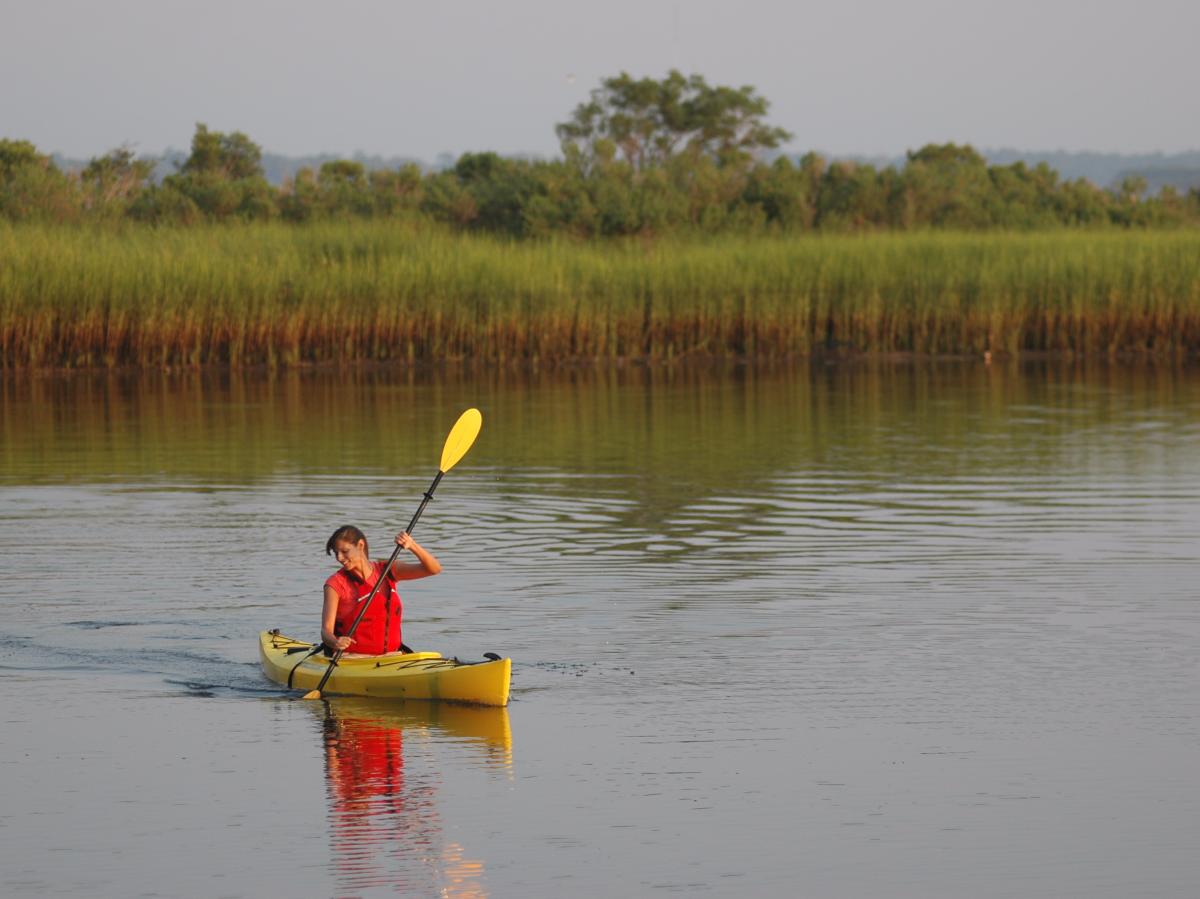 Woman in kayak in salt marsh
