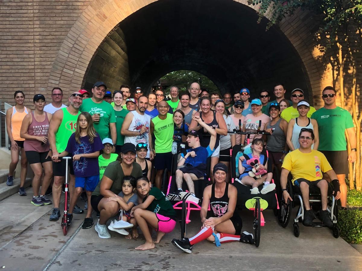 Large running club group standing in front of tunnel