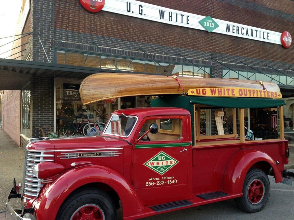 picture of outside of ug white with an old timey truck out front