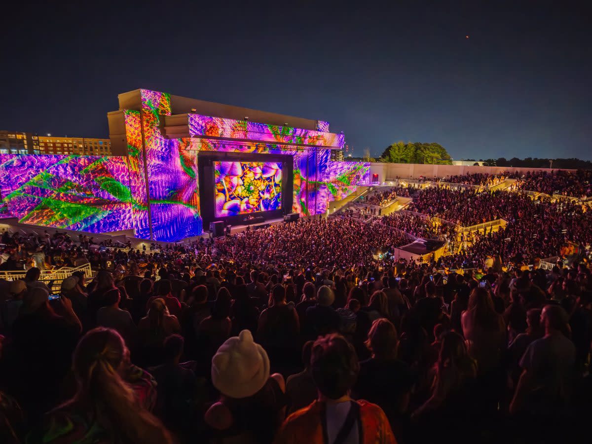 Pic of the Orion Amphitheater during a concert with a crowd of people. Colorful lights