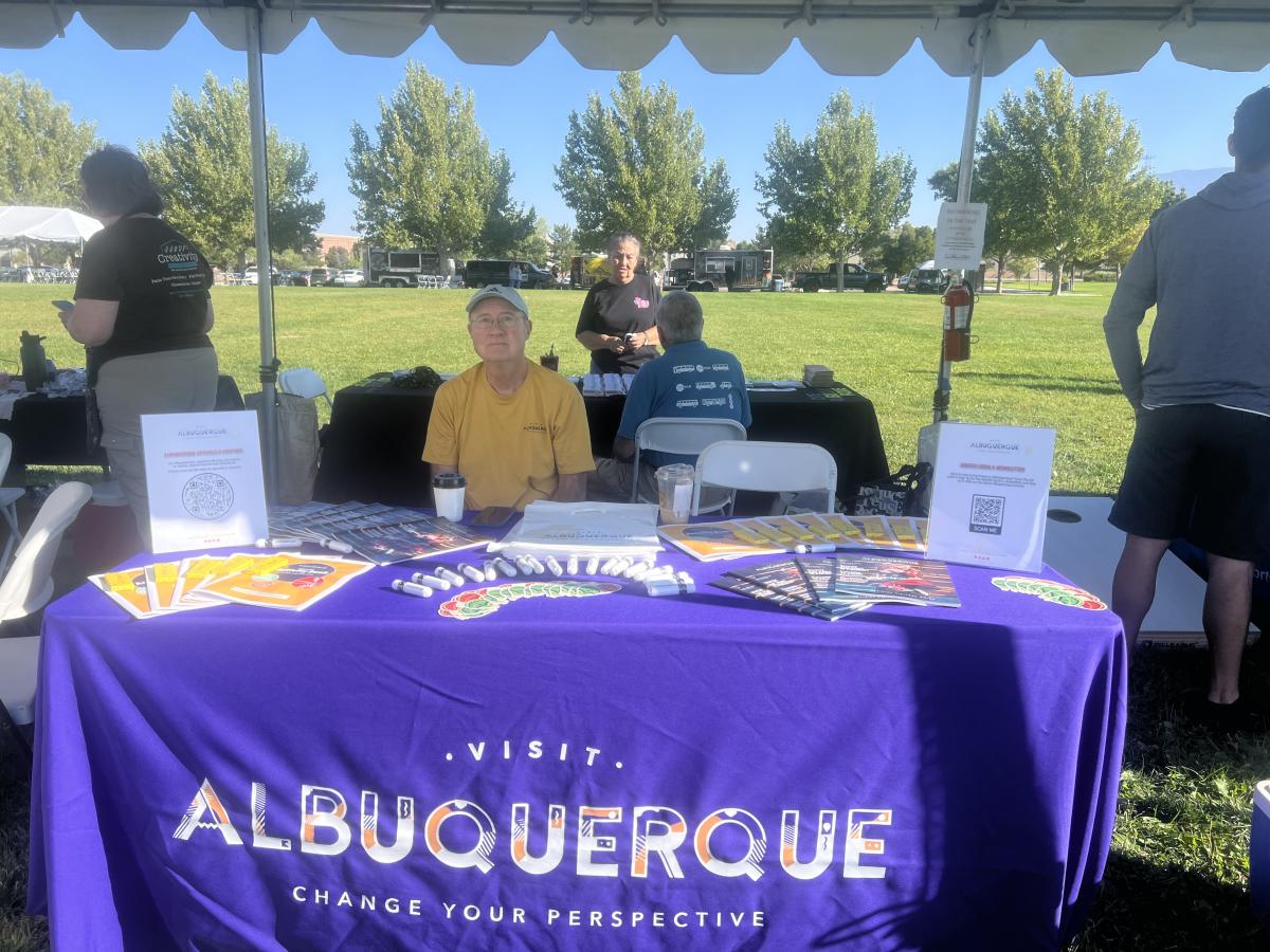 Wayne sits at the Visit Albuquerque booth at the Sandia Family Day.