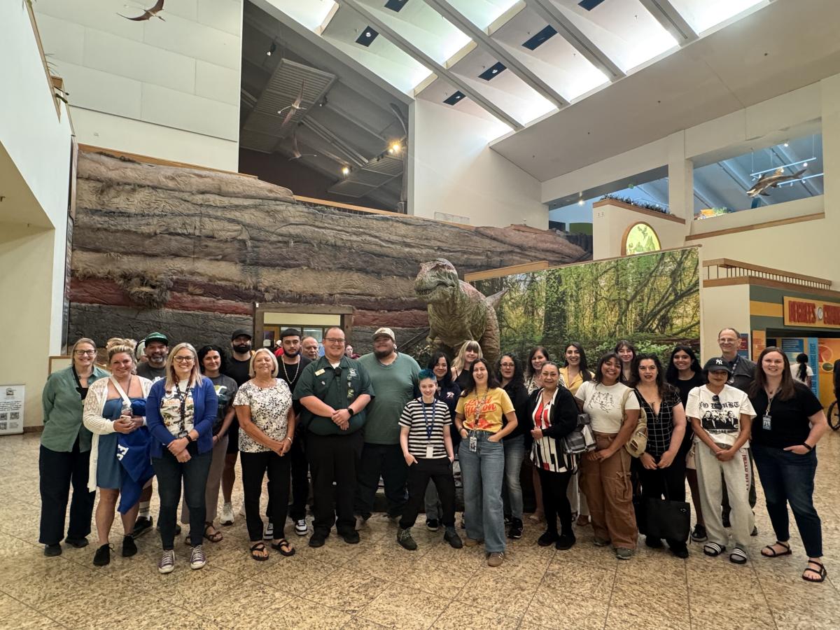 A photo of the ACE attendees at the New Mexico Museum of Natural History & Science. Everyone stands in front of the Bisti Beast exhibit.