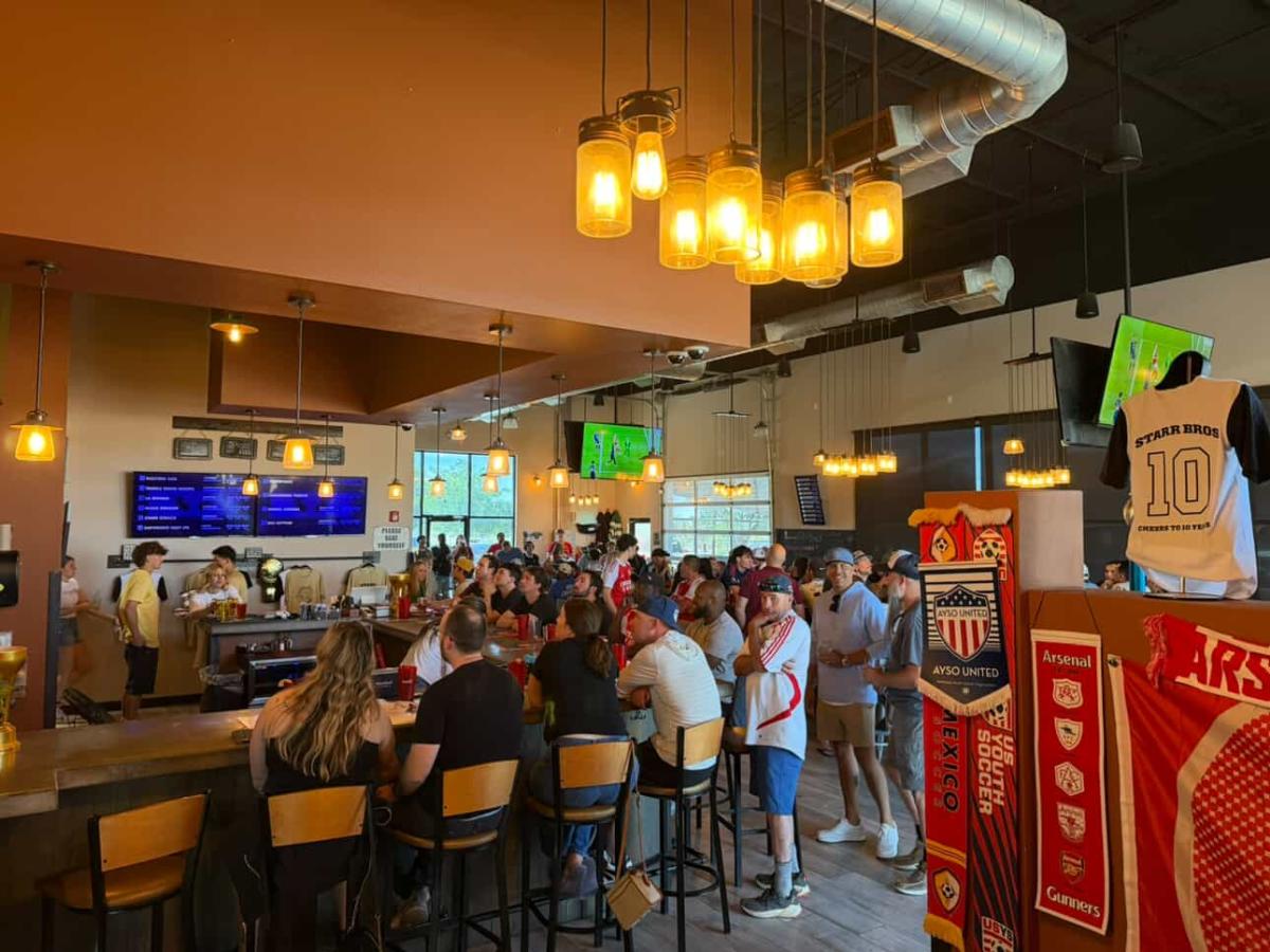 People gather at Starr Brothers Brewing Co. to watch a soccer game.