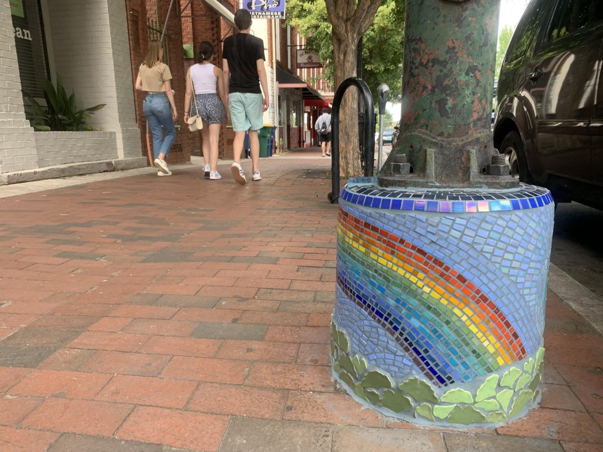 rainbow mosaic at the bottom of a light pole