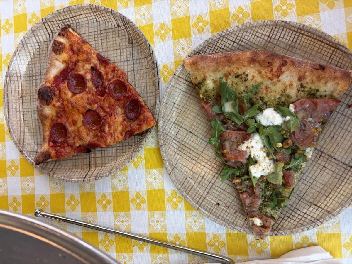 Two slices of pizza on a checkered yellow table cloth