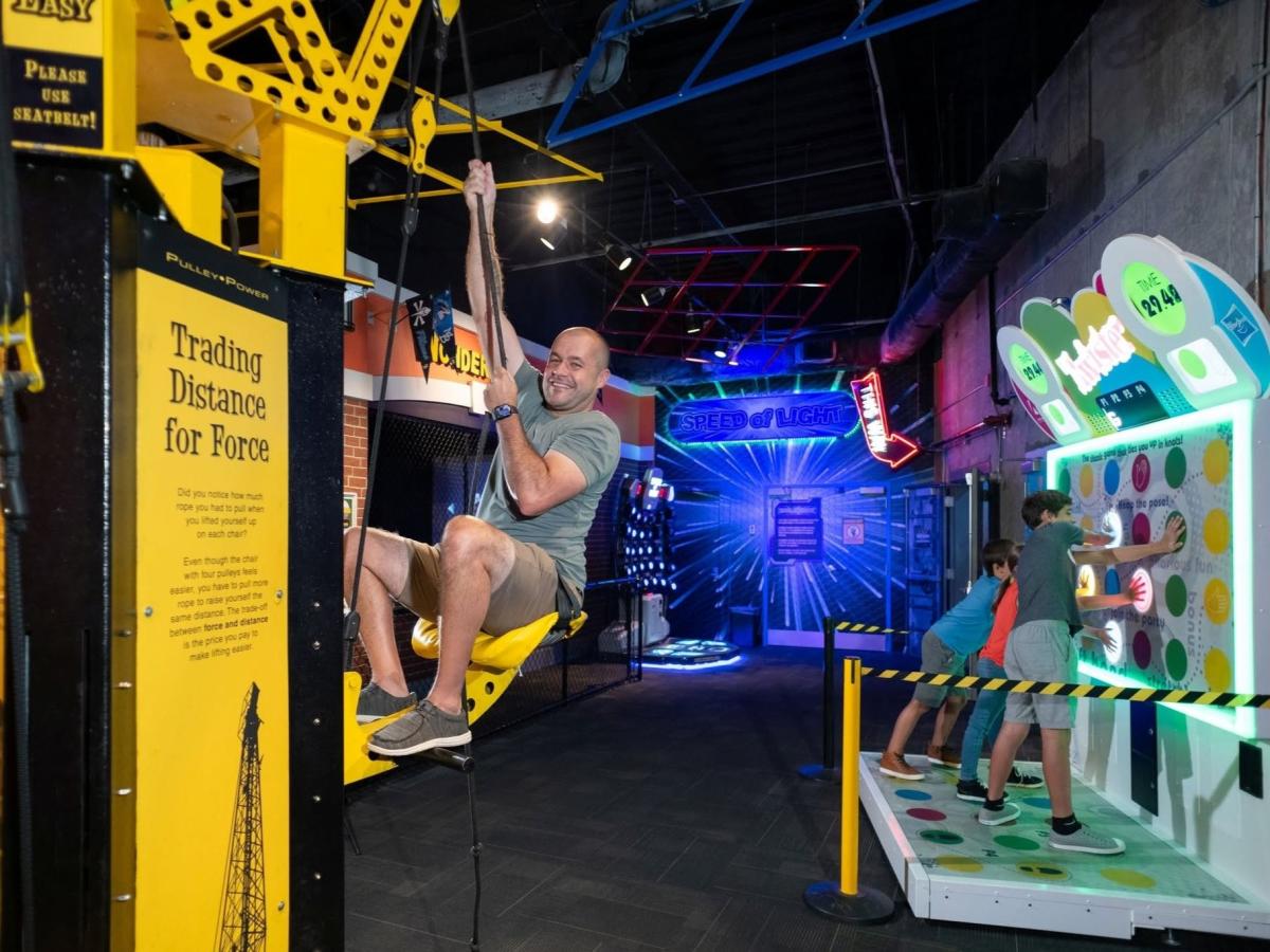 Visitor interacting with hands-on science exhibits inside WonderWorks indoor attraction in Branson