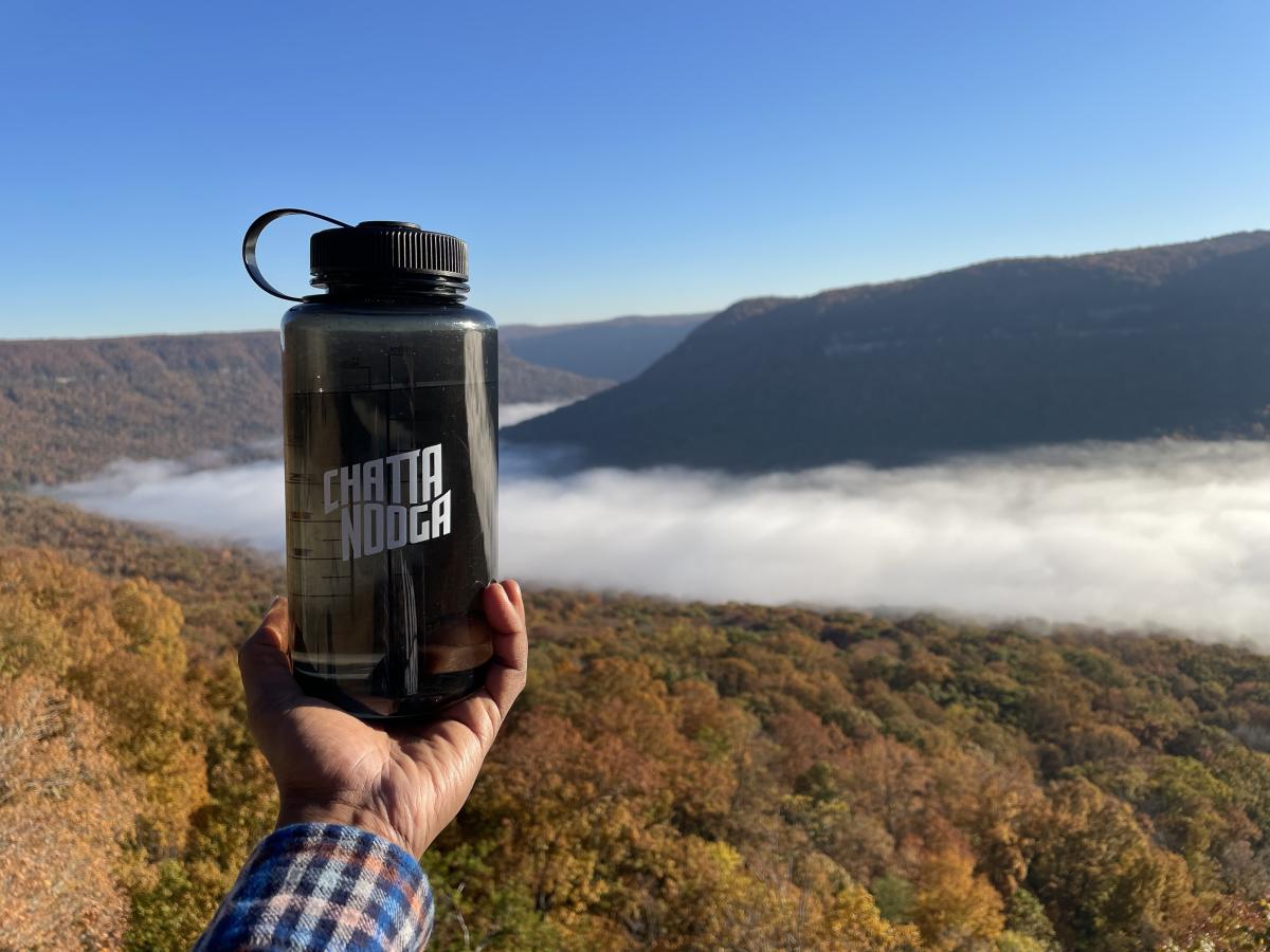 person holds CHATTANOOGA water bottle at overlook