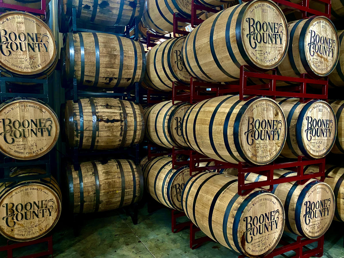 Bourbon barrels stamped with Boone County and stacked on red shelves