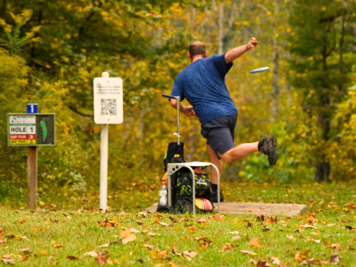 Man throwing disk golf at Rotary Park