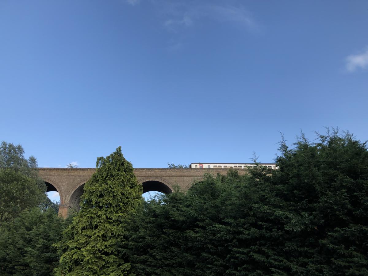 A train runs along the Sudbury Line towards the East Anglian Railway Museum