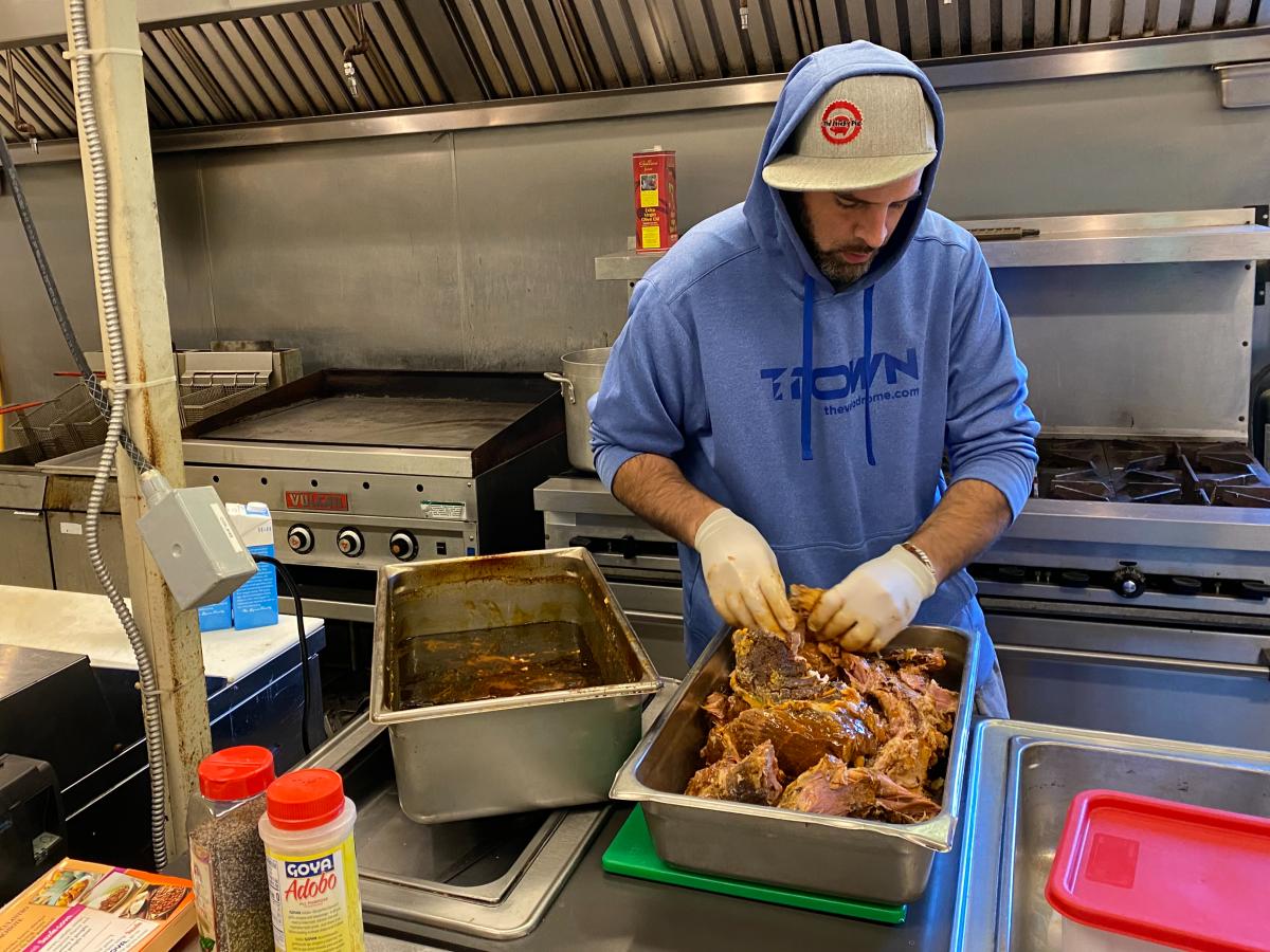 Charlie Wehr, co-owner of The Sticky Pig Food Truck, preps pulled pork at Valley Preferred Cycling Center in Breinigsville, Pa.