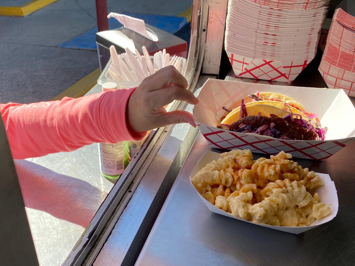 A customer picks up their order at the Sticky Pig Food Truck at Valley Preferred Cycling Center in Breinigsville, Pa.