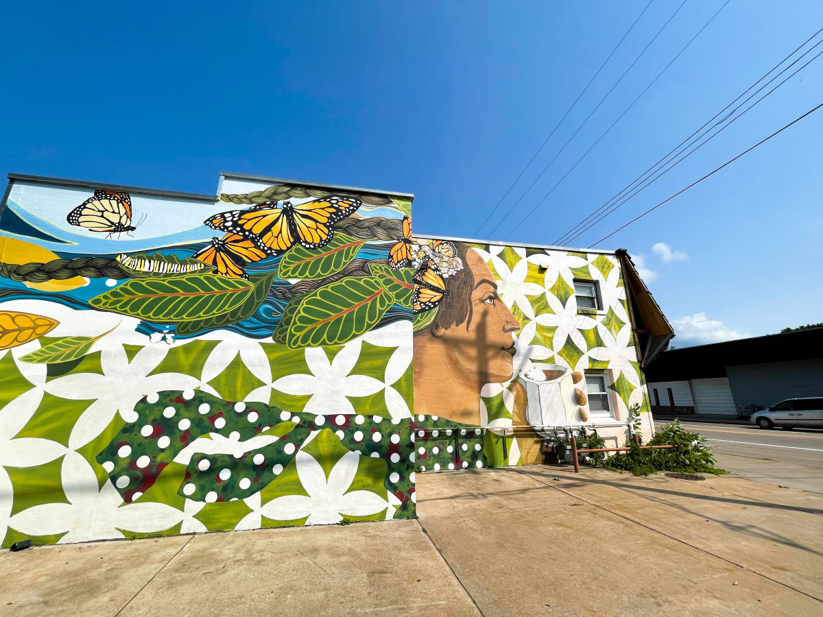 Mural located on side of building on Birch St. of a woman with butterflies flying around her head