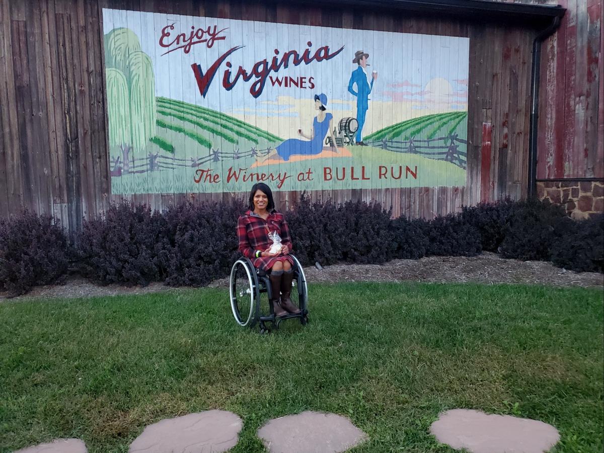 Maggie in front of an Enjoy Virginia Wines mural at the Winery at Bull Run in Fairfax County, Virginia