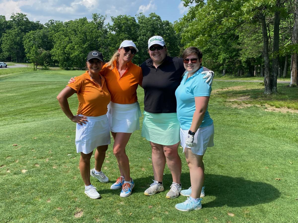 Women standing on a golf course posing for camera