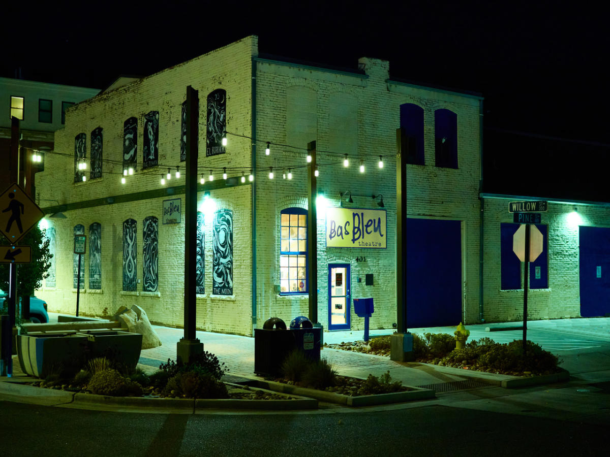 Exterior of Bas Bleu building. A white building with twinkle lights in front of it