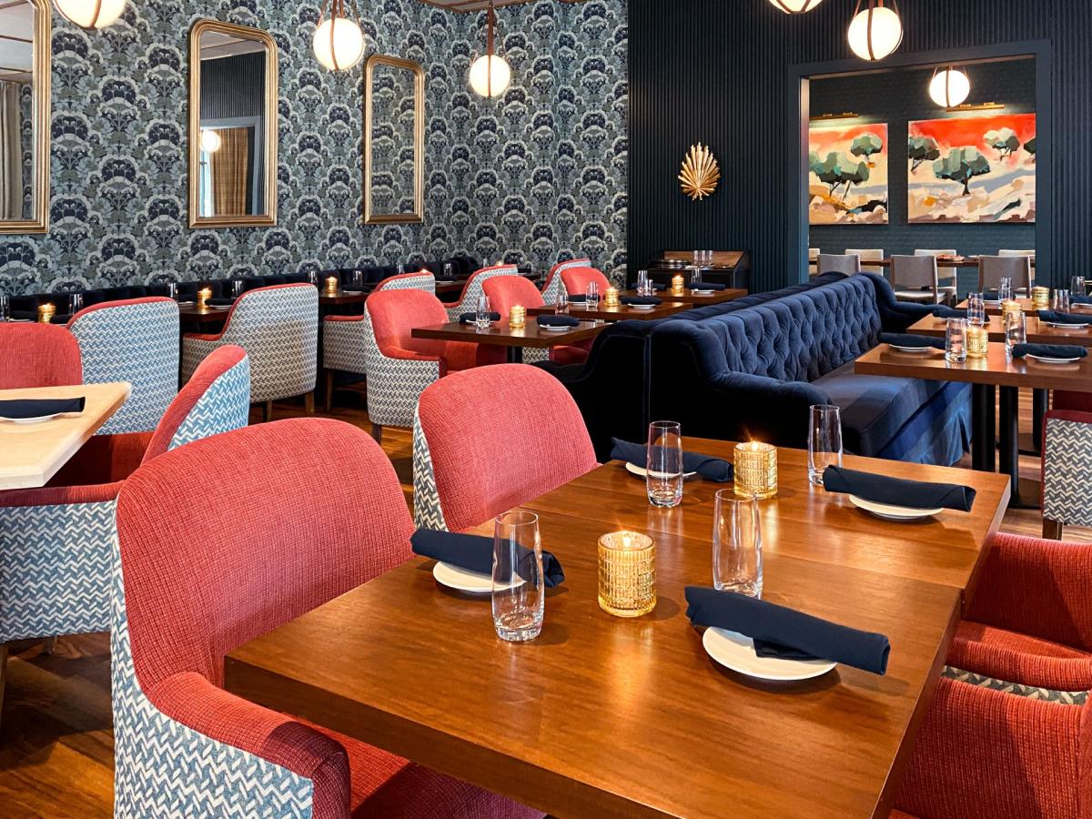 A view of the dining room at Arbor, the 1st floor restaurant at the Bradley Hotel. Soft chairs and couches are seated with wooden tables for an upscale ambience.