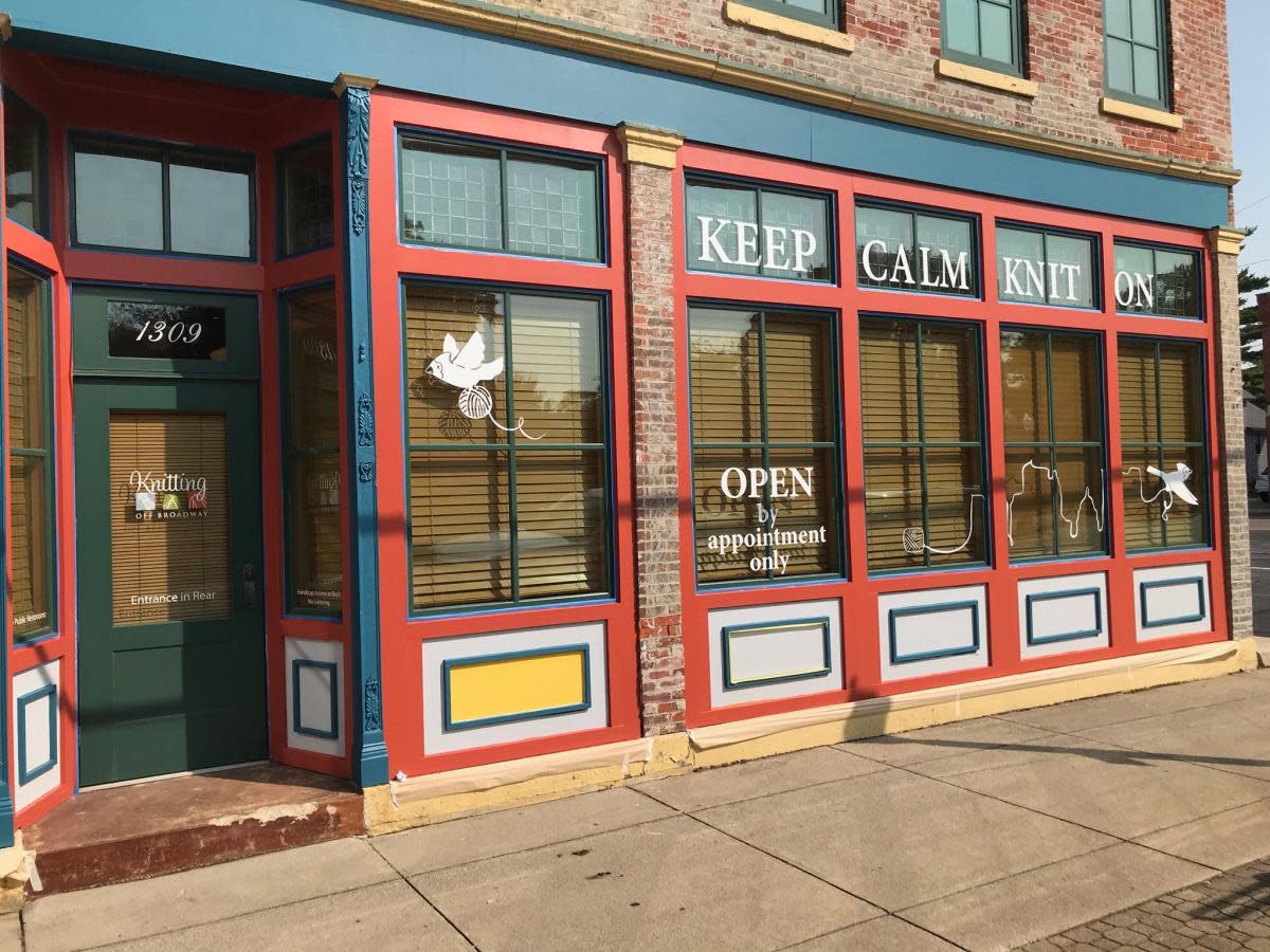 The storefront of Knitting off Broadway, text on windows reads "Keep Calm Knit On"